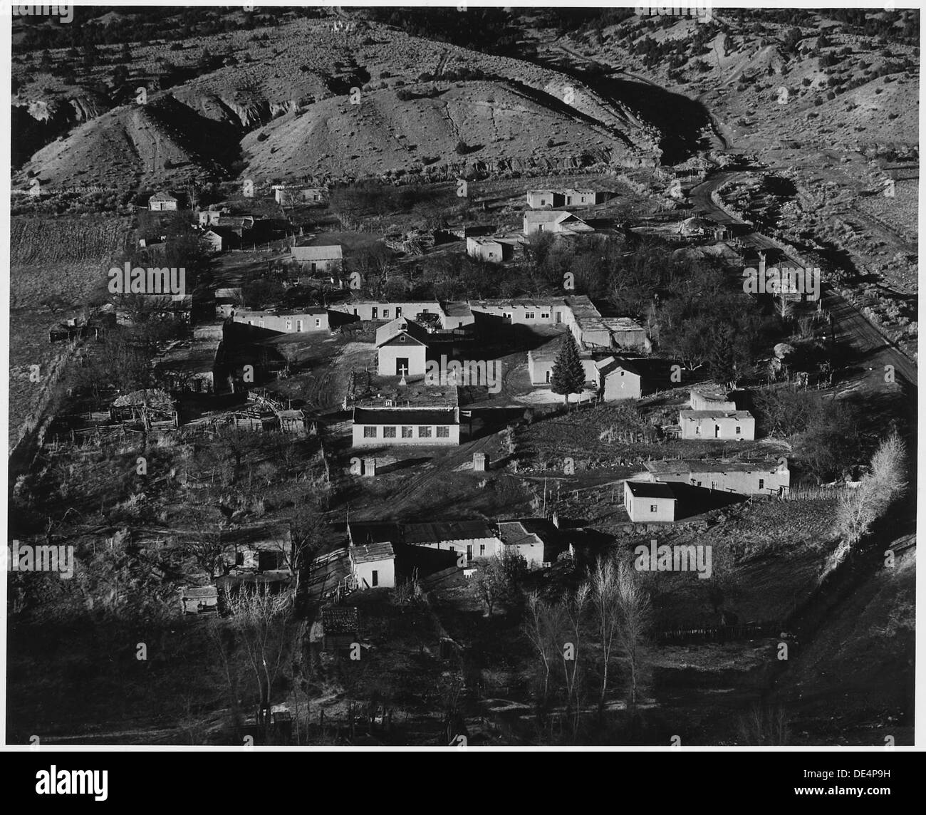 Taos County, Nuovo Messico. Vista di Valdez. Nota disposizione di case in piazza intorno alla chiesa, un styl . . . 521935 Foto Stock