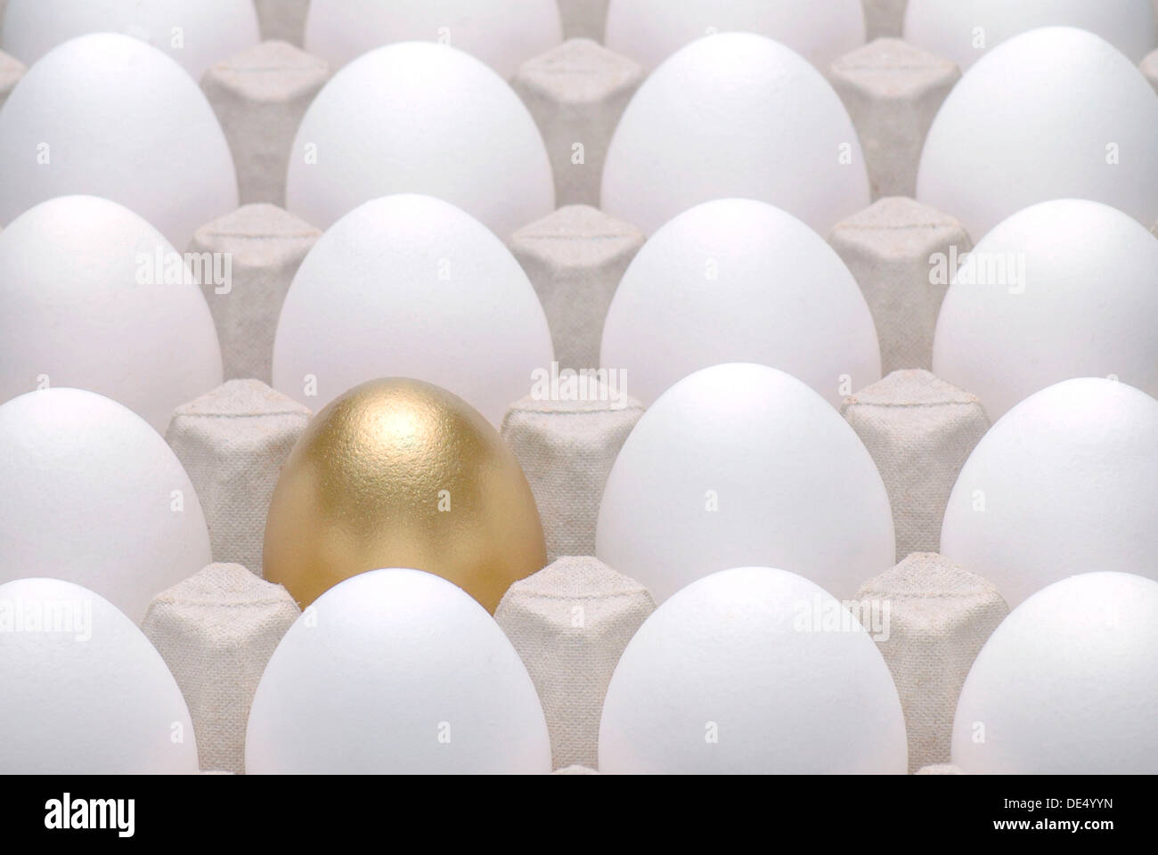Golden Egg in mezzo le uova bianche, immagine simbolica per essere diversi, in piedi fuori dalla folla Foto Stock