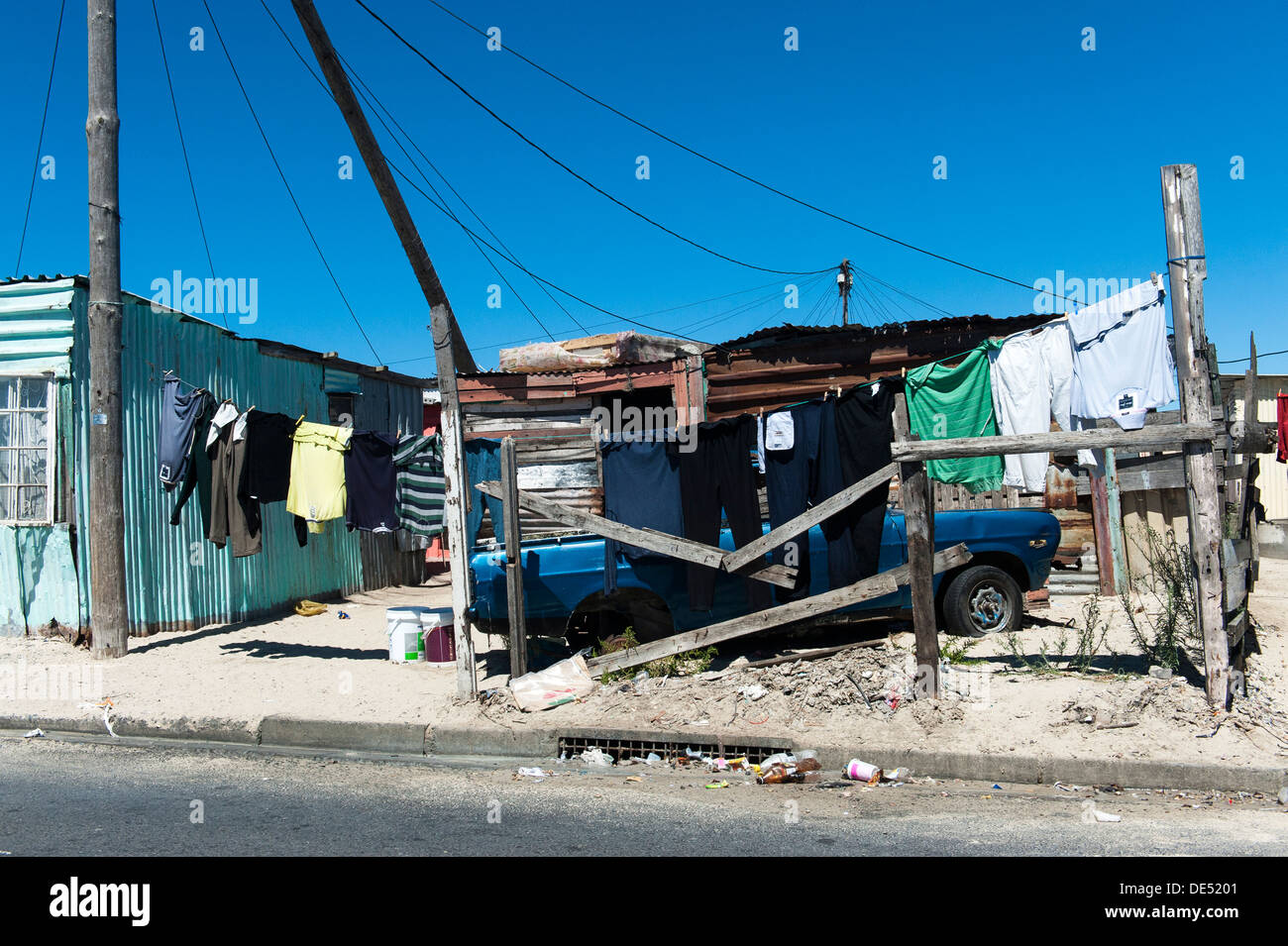 Servizio lavanderia, auto parcheggiata e stagno shack a Khayelitsha, un informale parzialmente township di Cape Town, Western Cape, Sud Africa Foto Stock