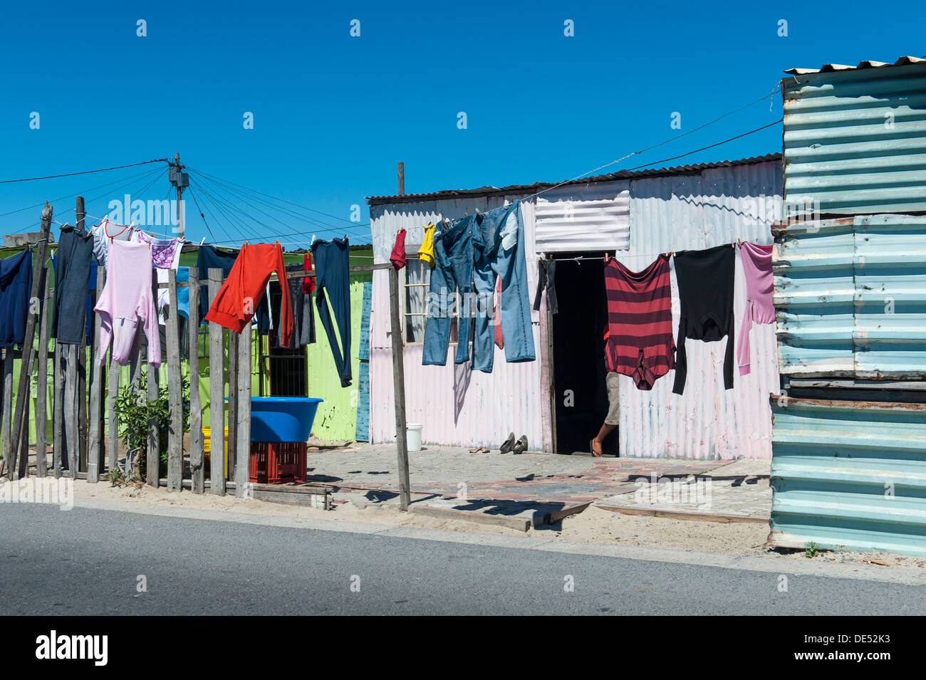 Servizio lavanderia appeso davanti a una capanna di stagno a Khayelitsha, un informale parzialmente township di Città del Capo in Sud Africa Foto Stock
