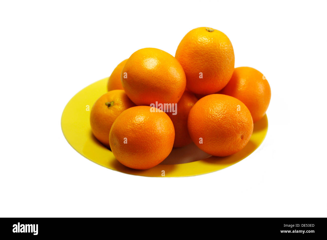 Arance, succose arance su una piastra di colore giallo Foto Stock