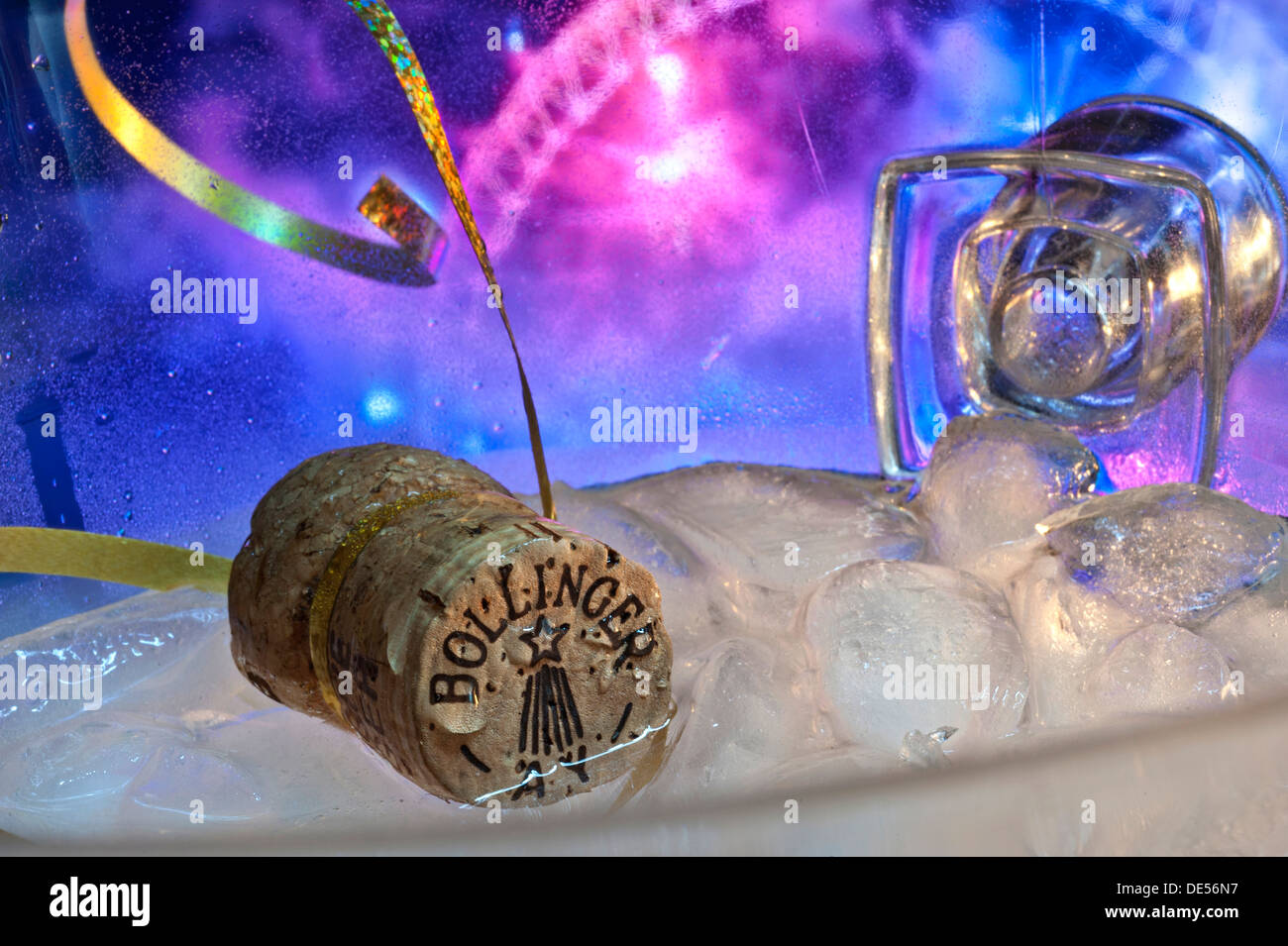 Bollinger Champagne galleggiante sul ghiaccio in wine cooler con oro streamers party fuochi d' artificio celebrazioni dietro Foto Stock