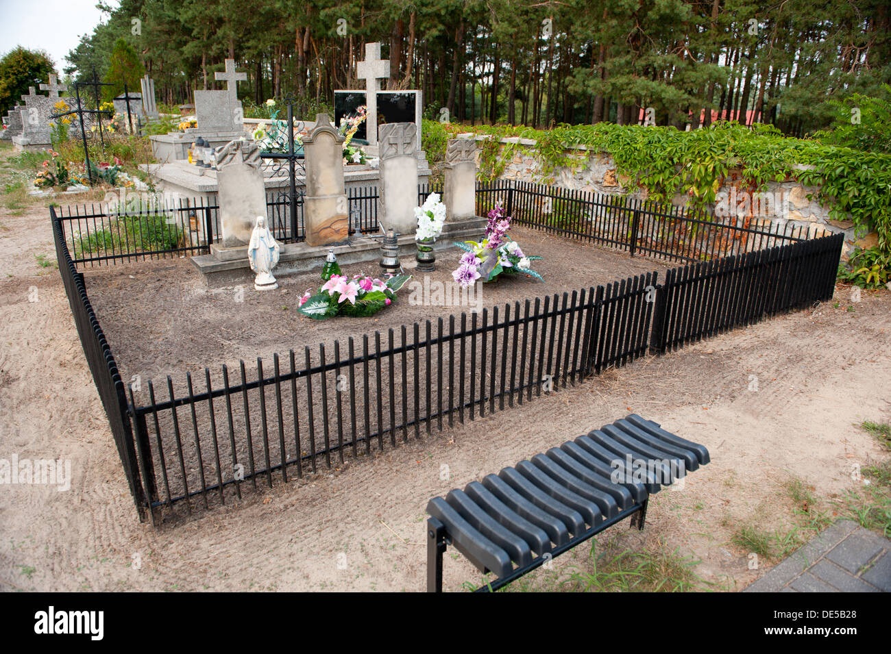 Tombe di famiglia con recinto e panca sul cimitero vicino bosco in Odrzywół, Polonia, Europa Foto Stock