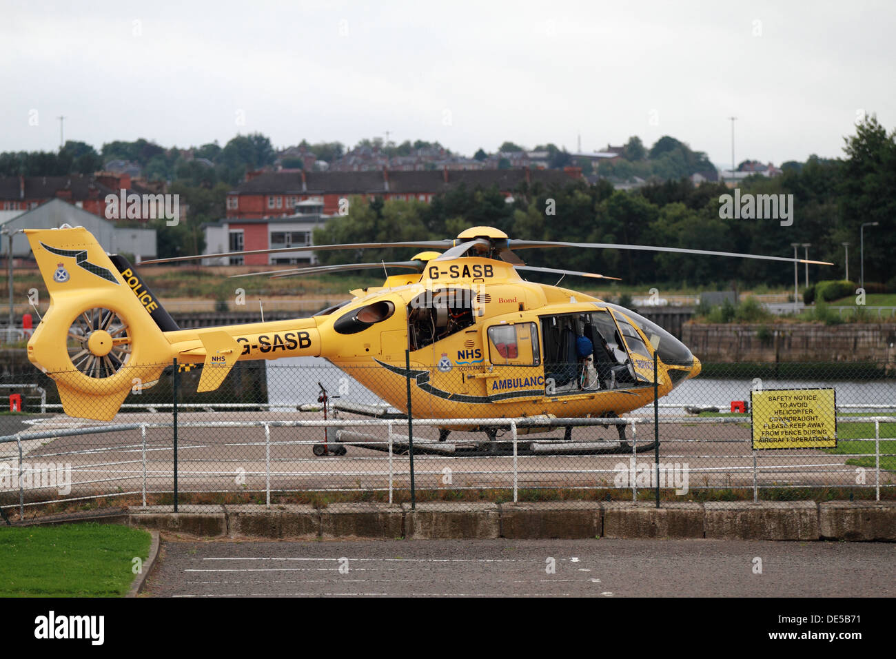 Scottish servizio ambulanza elicottero giallo collegato a massa sul fiume Clyde stazione dock port Foto Stock
