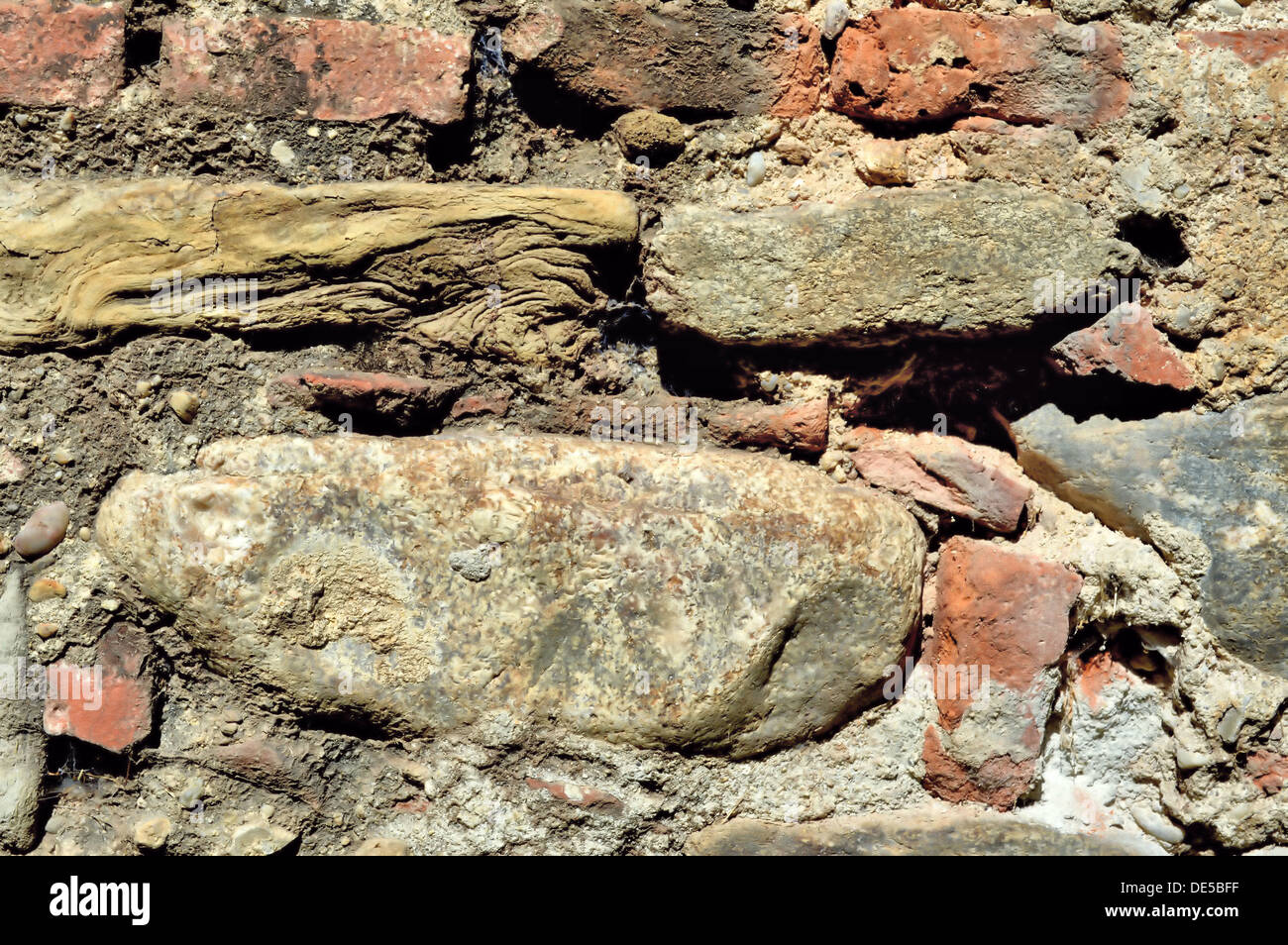 Un close-up di un vecchio muro di fortificazione texture, fatta di mattoni e pietra e malta di calce, fotografato a Sibiu in Transilvania, Romania. Foto Stock