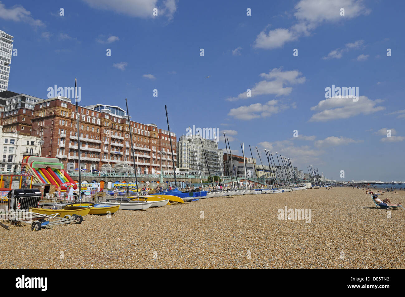 Vista lungo la spiaggia di Brighton con barche a vela a Pier Brighton East Sussex England Foto Stock