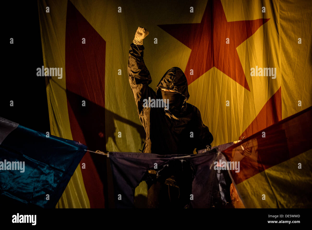 Barcellona, Spagna. Settembre 11th, 2013: mascherato pro-indipendenza attivisti masterizzare il francese, spagnolo e la bandiera dell'UE alla fine di una dimostrazione sulla Catalogna della giornata nazionale © matthi/Alamy Live News Foto Stock