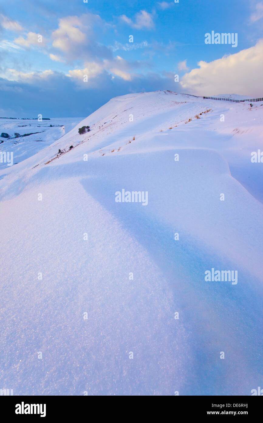 Vista guardando in alto Mam Tor a sunrise dopo alcuni pesanti nevicate. Mam Tor, Castleton, Derbyshire Peak District, REGNO UNITO Foto Stock