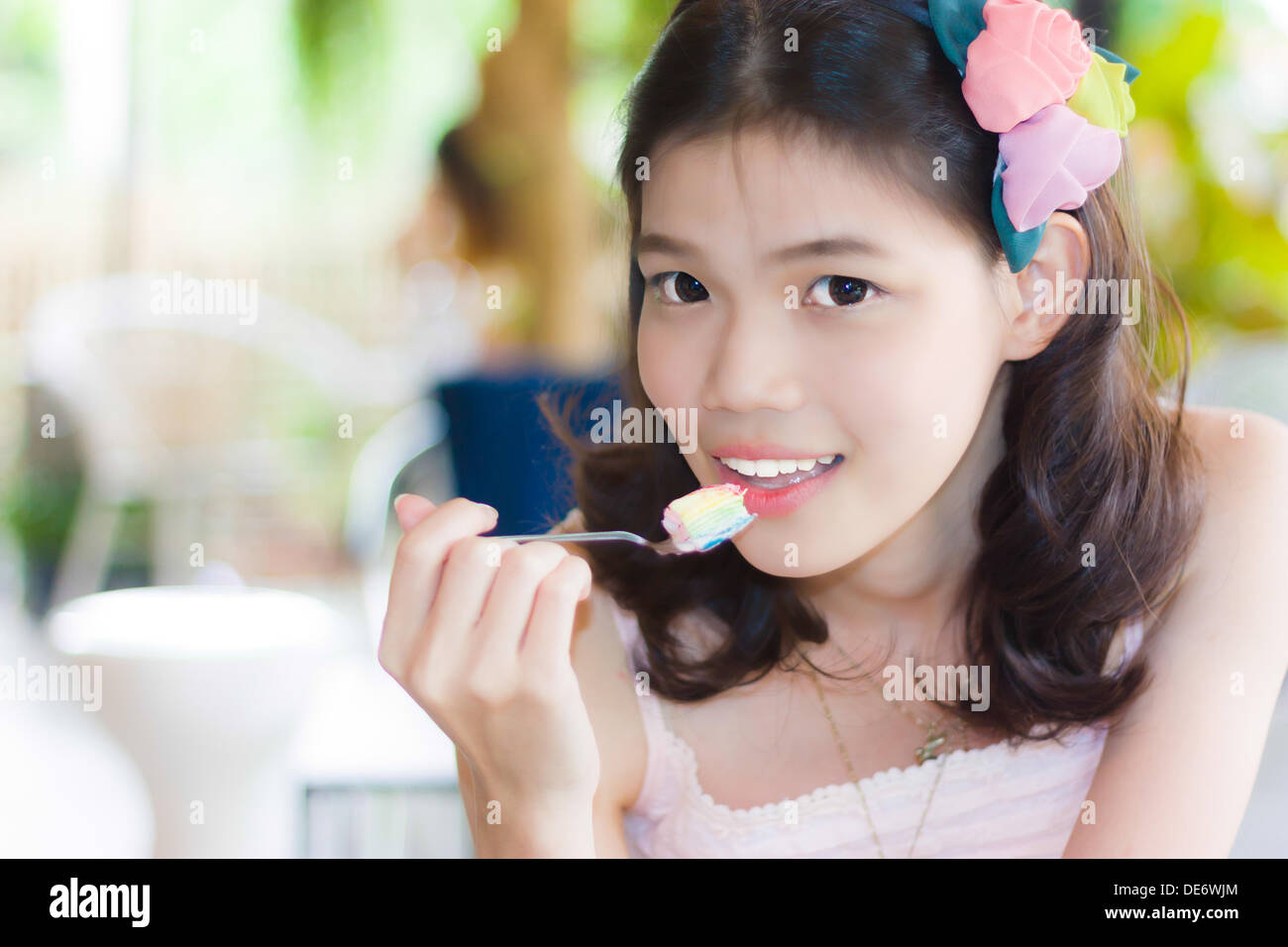 Ritratto ragazza tailandese di mangiare un cucchiaio di torta Foto Stock