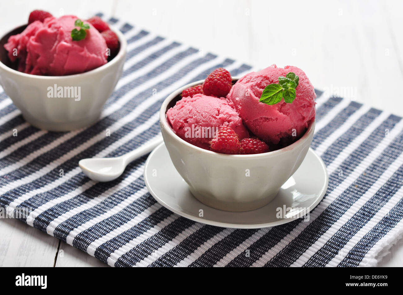 Gelato al lampone nel vaso in ceramica con frutti di bosco freschi e menta Foto Stock