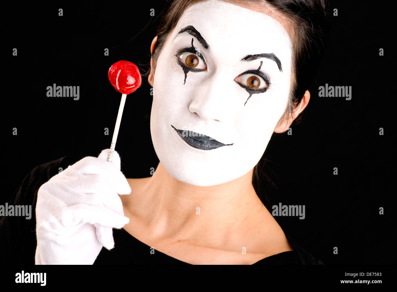 Donna realizzati con faccia bianca contiene rosso dolce lecca-lecca Foto Stock