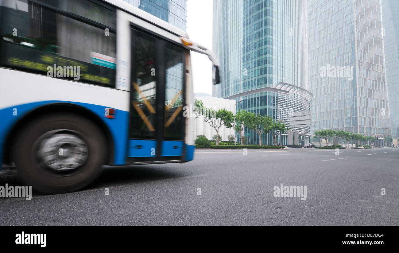 Una lunga esposizione foto di bus che si muove su strada urbana. Motion Blur su sfondo della città Foto Stock