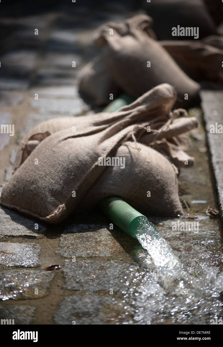 Muehl, Germania, sacchi di sabbia fissare un tubo flessibile durante il pompaggio fuori un piano seminterrato Foto Stock