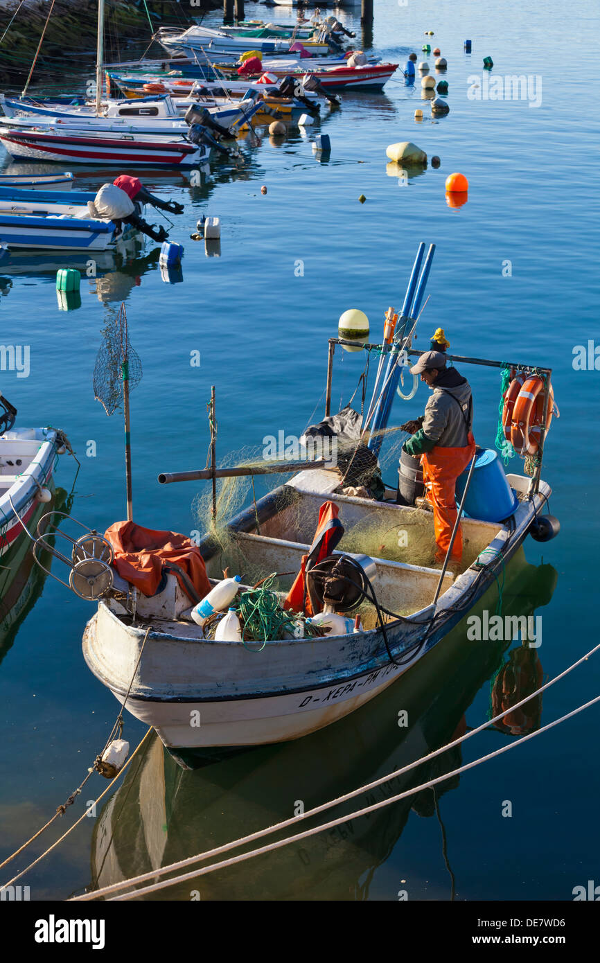 Il Portogallo, Lagos, Man Standing in barca da pesca a porto Foto Stock