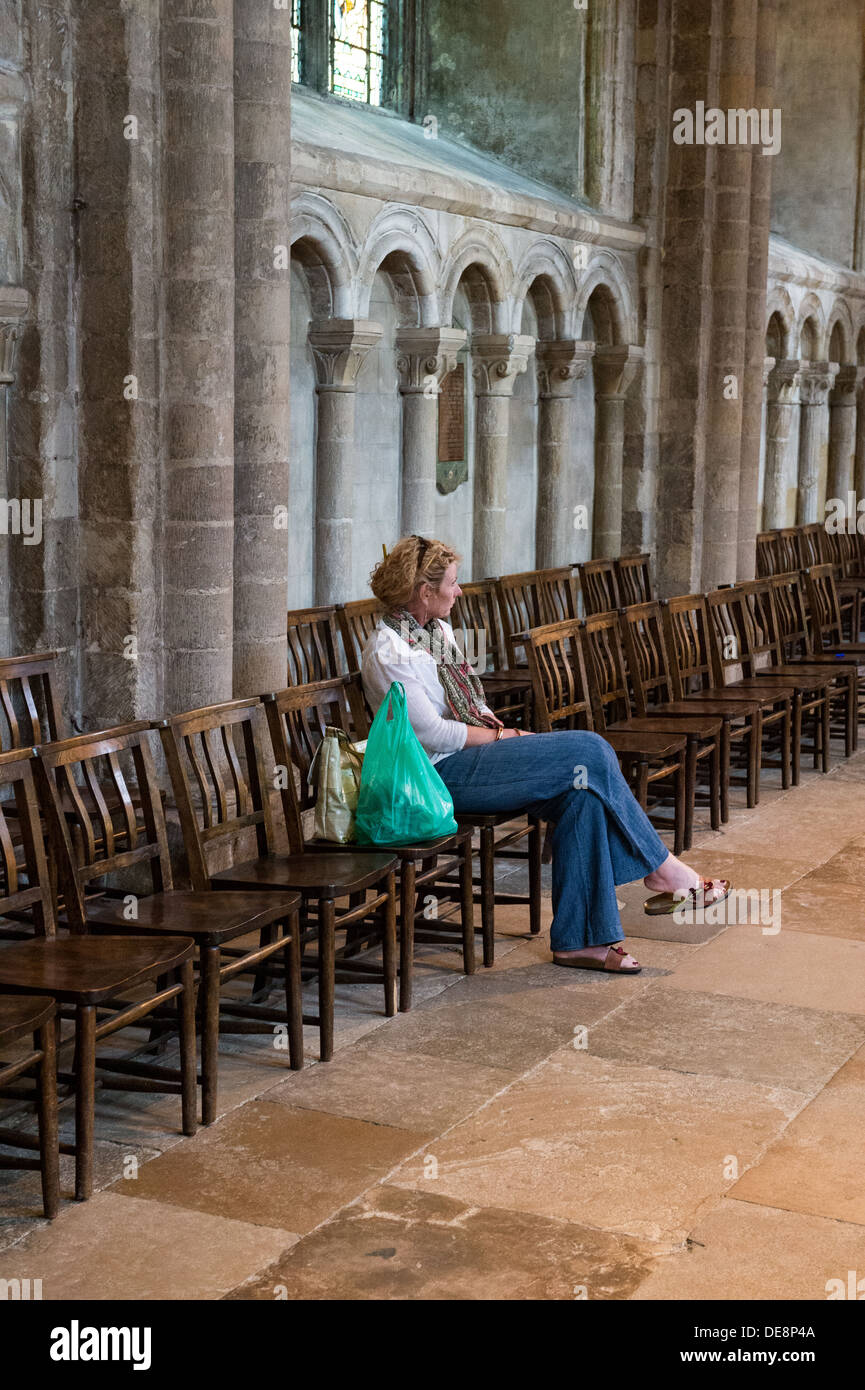 Donna seduta e contemplando in Norwich Cathedral. Foto Stock