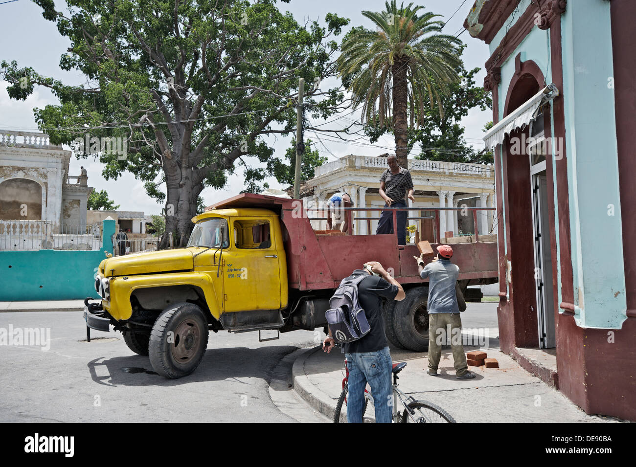 Santiago de Cuba, Cuba, membri di una brigata di costruzione invitare i mattoni di un carrello sovietica Foto Stock