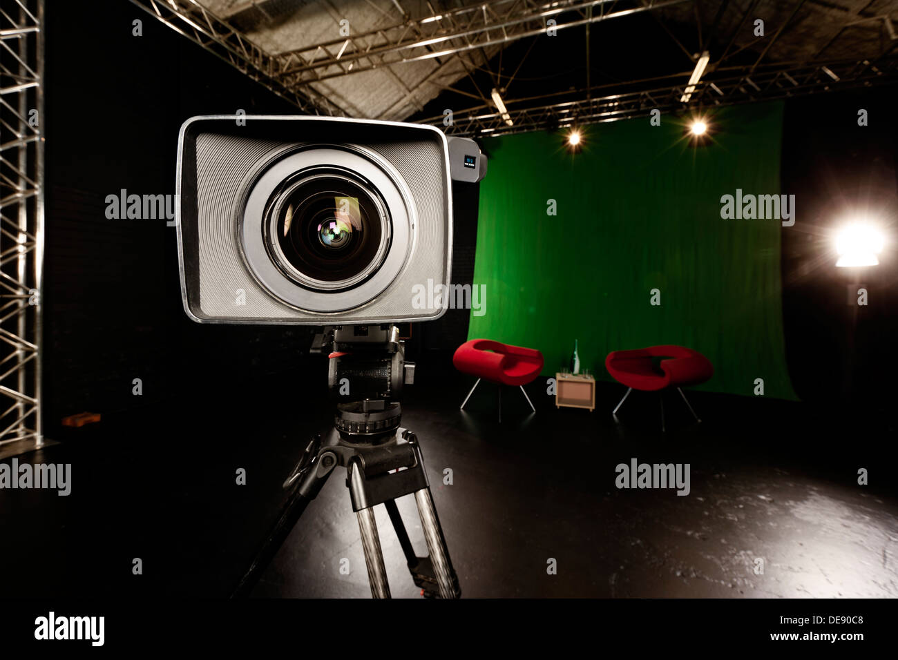 Close-up di una telecamera lente in una schermata verde ambiente di studio. Foto Stock