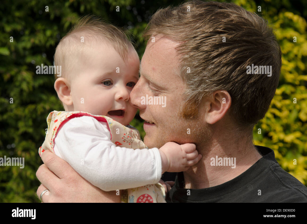 Giovane padre con otto mesi ragazza in giardino Foto Stock