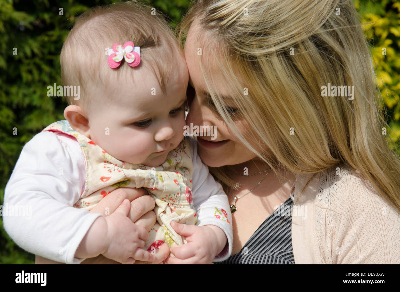 Giovane madre con otto mesi ragazza in giardino Foto Stock