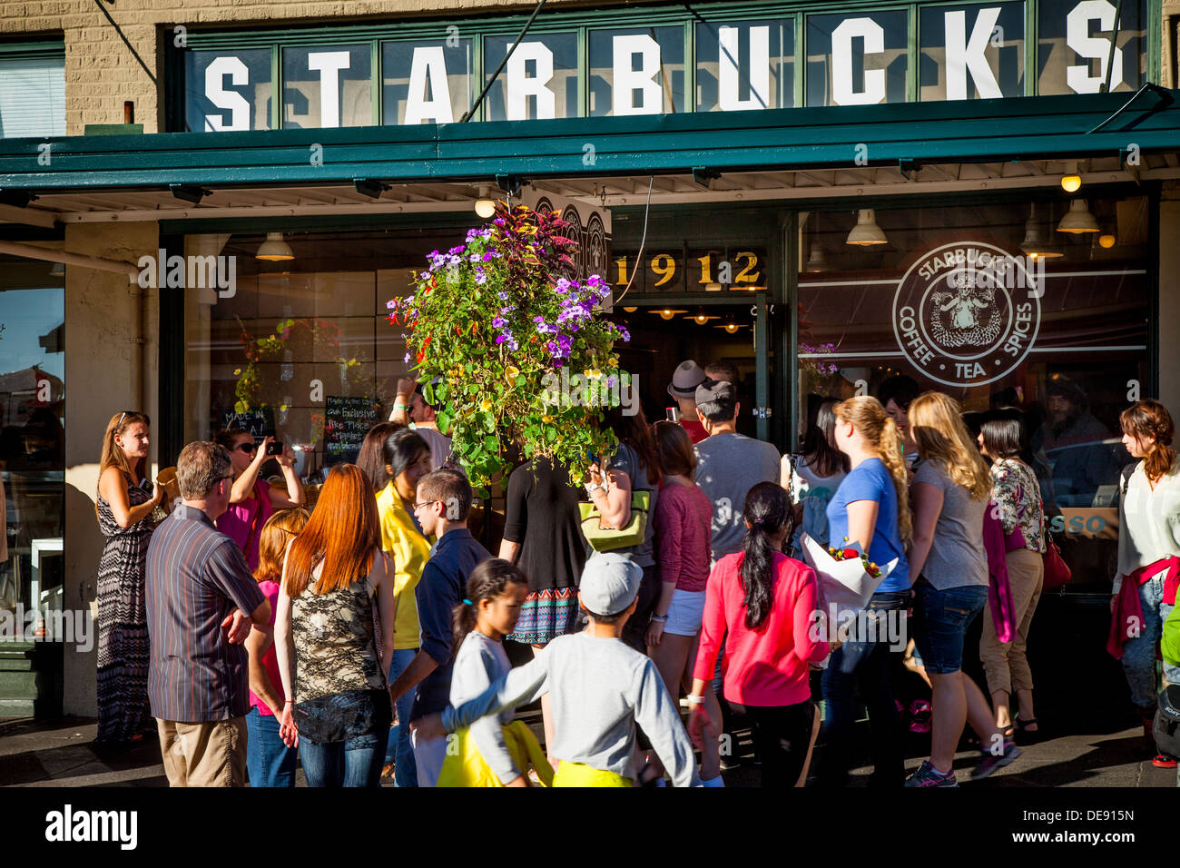 La folla di persone che circonda l'originale Starbucks Coffee Shop presso il Mercato di Pike Place, Seattle Washington STATI UNITI D'AMERICA Foto Stock