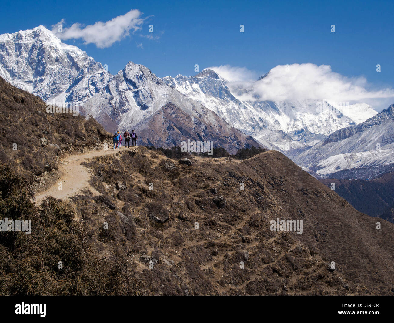 Trekking a piedi lungo il sentiero per il Campo Base Everest in Nepal con il dark summit del Monte Everest in background. Foto Stock