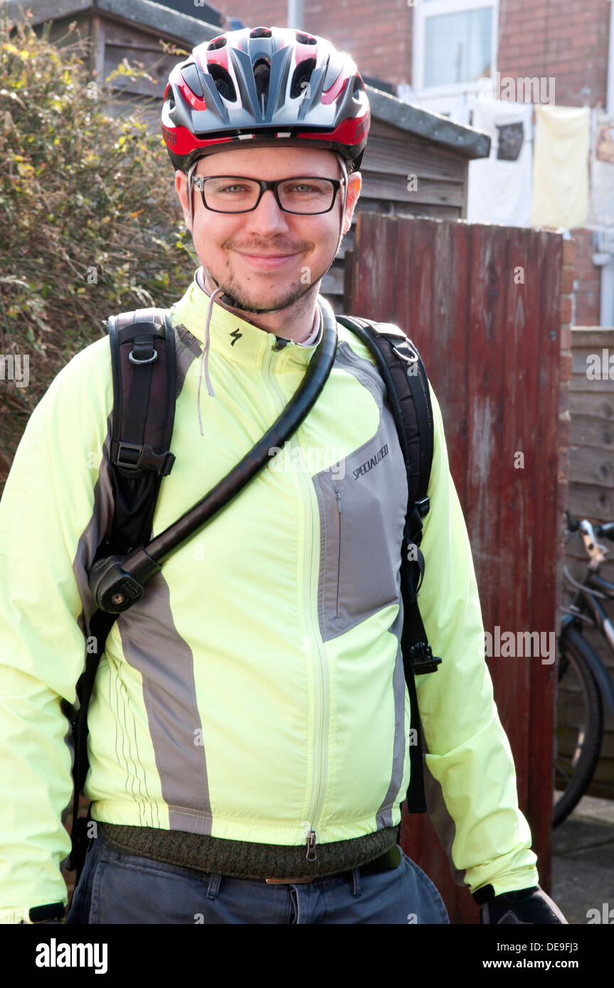 Ritratto di un uomo che indossa abiti in bicicletta, casco e occhiali sorridente Foto Stock