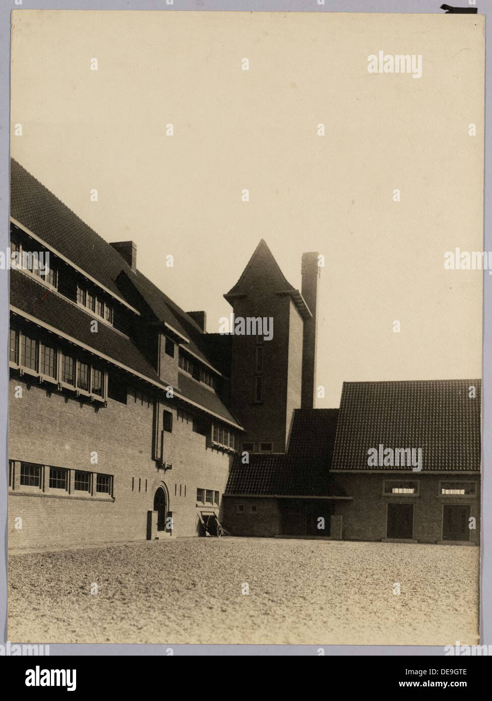 Questo edificio scolastico di Rotterdam, costruito tra il 1920 e il 1930, dispone di un parco giochi progettato per le attività ricreative dei bambini. L'edificio e i suoi dintorni riflettono i principi architettonici olandesi dell'epoca, con particolare attenzione agli spazi funzionali per l'istruzione. Foto Stock