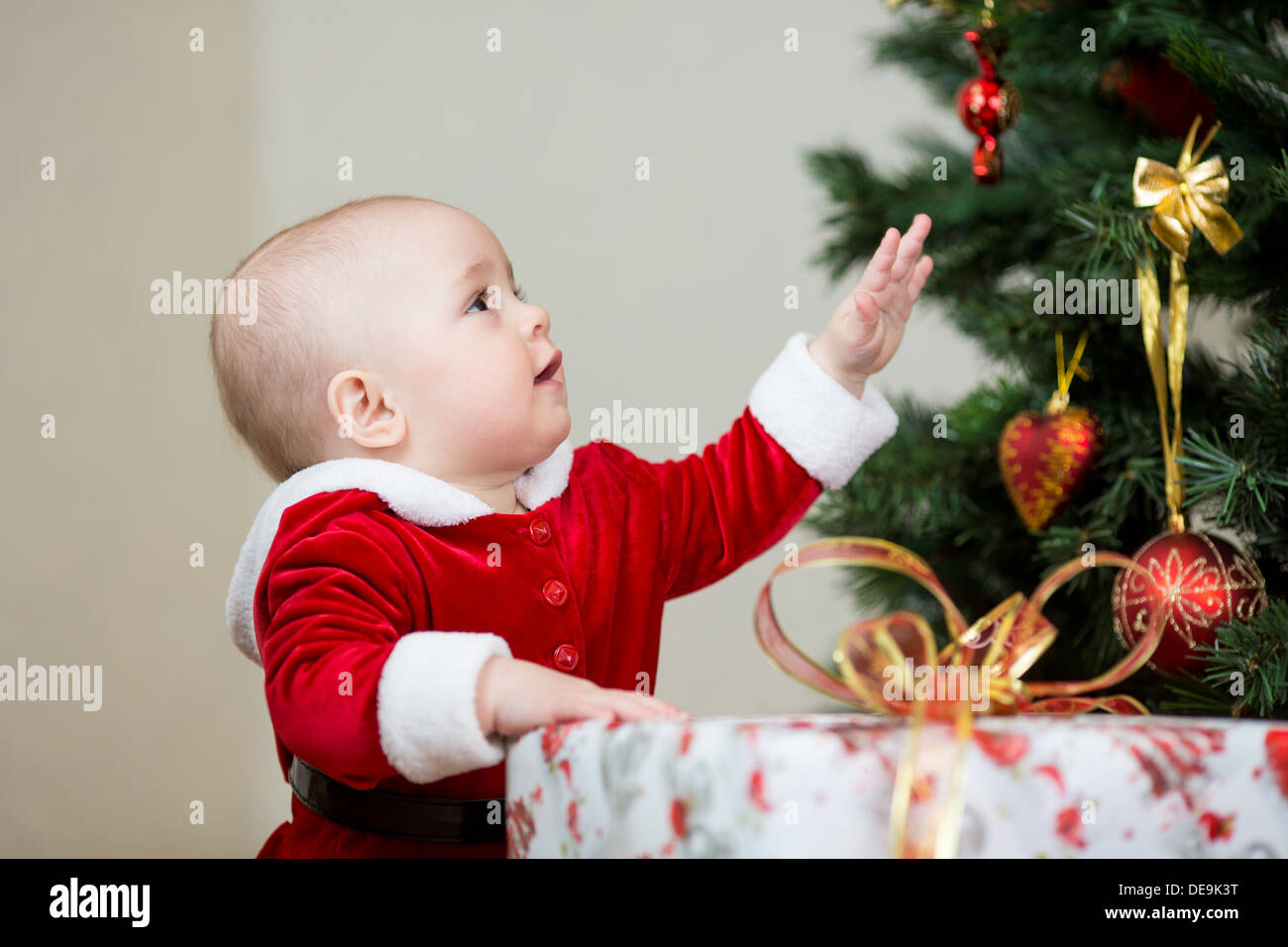 Piuttosto bambino con il regalo al albero di Natale Foto Stock