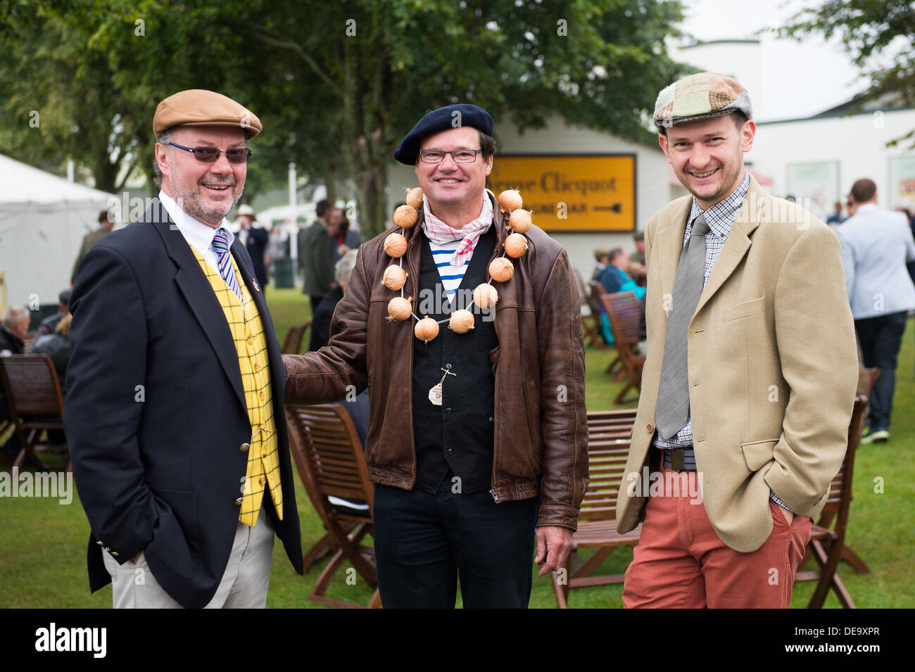 Chichester, West Sussex, Regno Unito. Xiii Sep, 2013. Goodwood. Goodwood Racing circuito, West Sussex - Venerdì 13 Settembre. Tre uomini vestiti in periodo di abbigliamento, compresa una cipolla francese venditore rilassarsi in un open air zona pranzo. © MeonStock/Alamy Live News Foto Stock