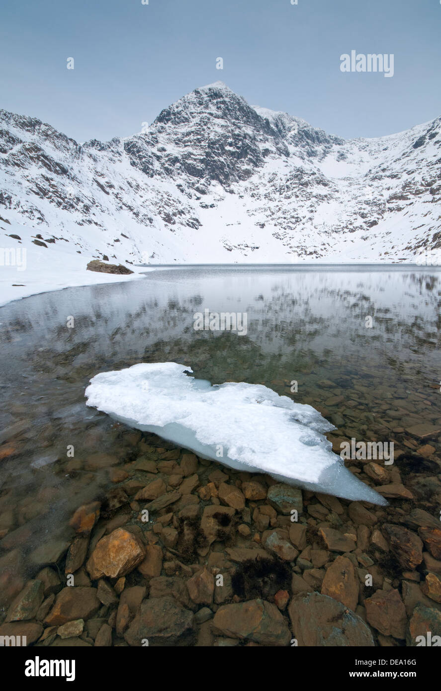 Formazioni di ghiaccio in Llyn Glaslyn e Snow capped picco di Mount Snowdon, Snowdonia National Park, North Wales, Regno Unito Foto Stock
