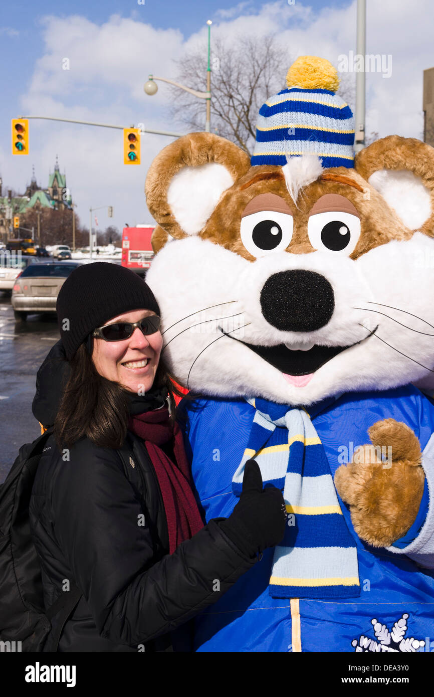 Ragazza in posa con Winterlude mascotte. Winterlude è un festival annuale di Ottawa, Ontario, Canada che celebra l'inverno. Foto Stock