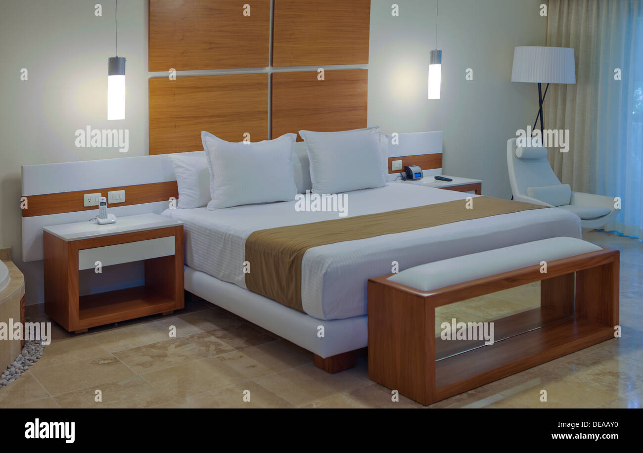 Camera interna in una casa o un albergo con un arredamento minimalista in tonalità neutre e di un ampio letto doppio Foto Stock