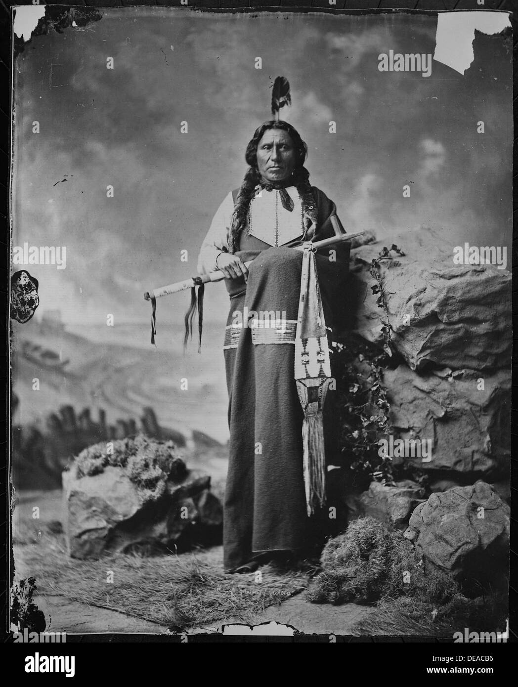 Questo ritratto a figura intera cattura un individuo Dakota, mostrando abbigliamento tradizionale e patrimonio culturale. Foto Stock