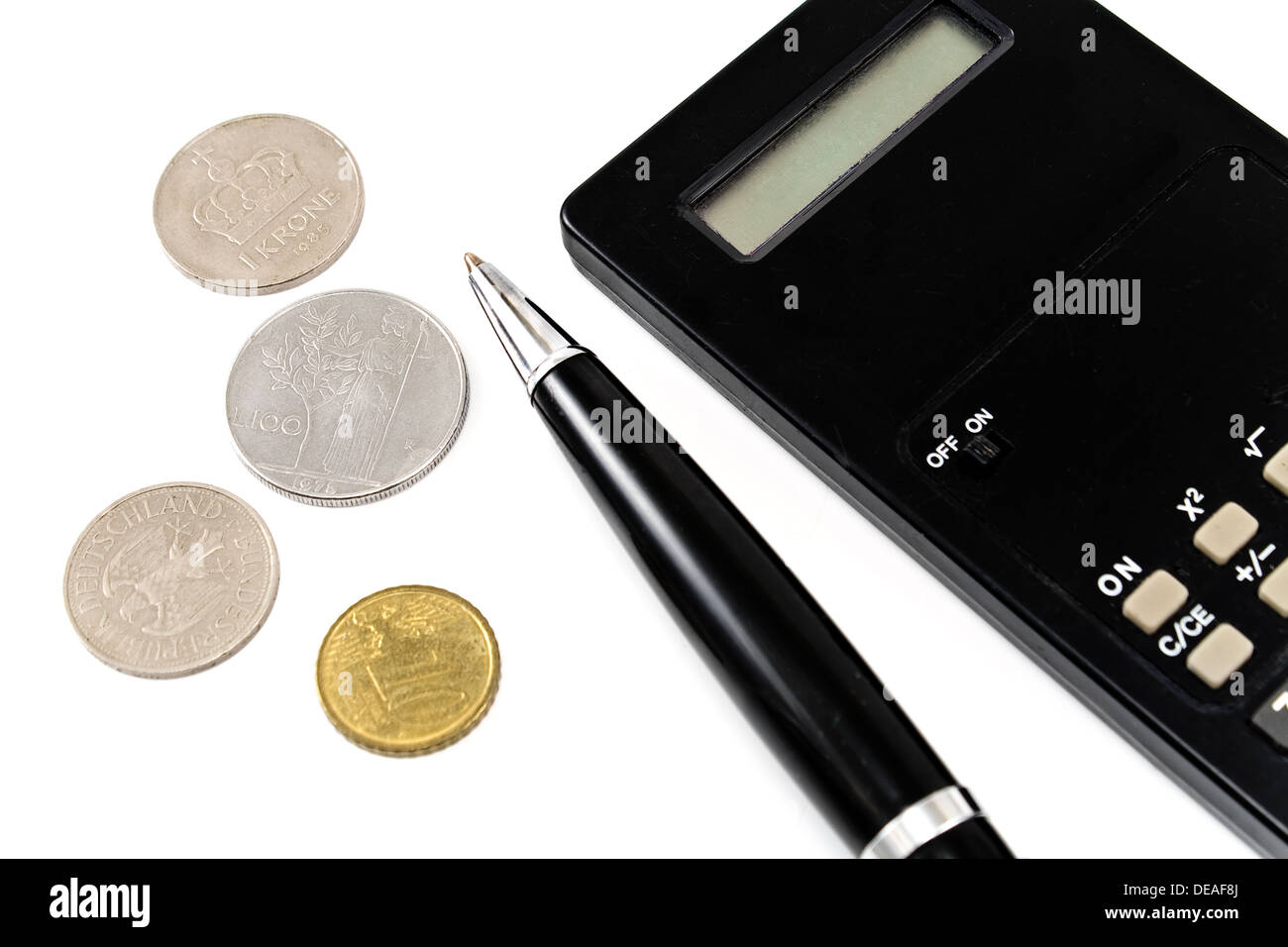 Calcolatrice, penna e vecchie monete europee isolato su bianco Foto Stock