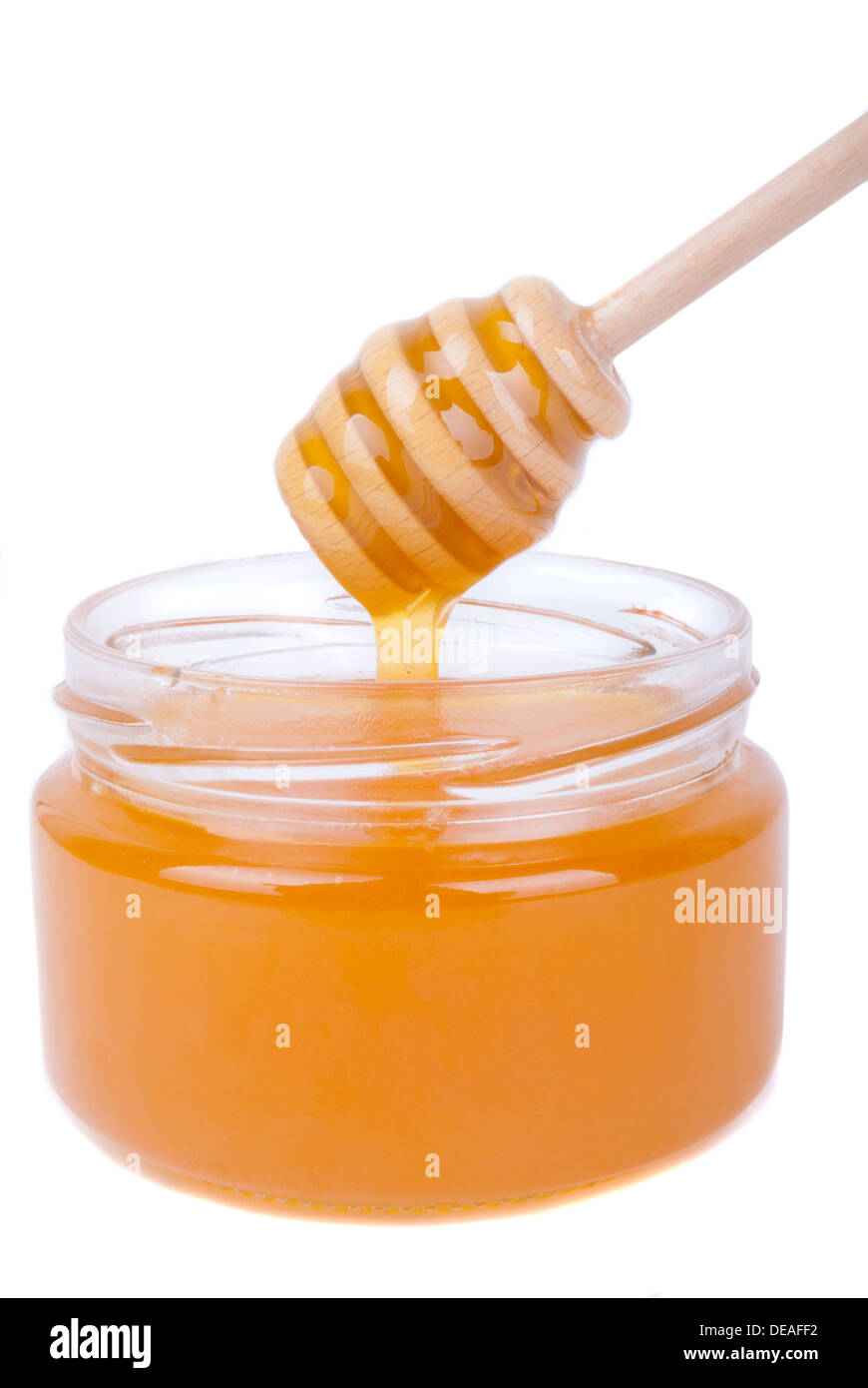 Il miele gocciolamento in un vaso con un cucchiaio speciale. Foto Stock