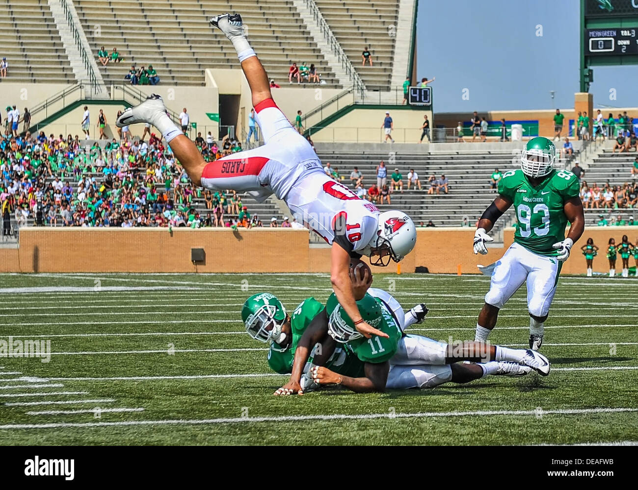 Sett. 14th, 2013:.sfera membro Cardinali quarterback Keith Wenning (10) va airborne come egli è affrontato da nord Texas verde medio linebacker Zach OR (35) e nord Texas verde medio linebacker Will Wright (11) in un NCAA Football gioco tra la sfera membro cardinali e il nord Texas aquile presso lo stadio di Apogee in Denton, Texas.. Foto Stock