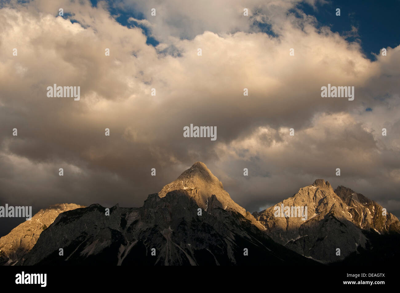 Ultima luce del sole che splende su picchi di Mieming gamma con le montagne Ehrwalder Sonnenspitze e Gruenstein, Ehrwald, Tirolo Foto Stock