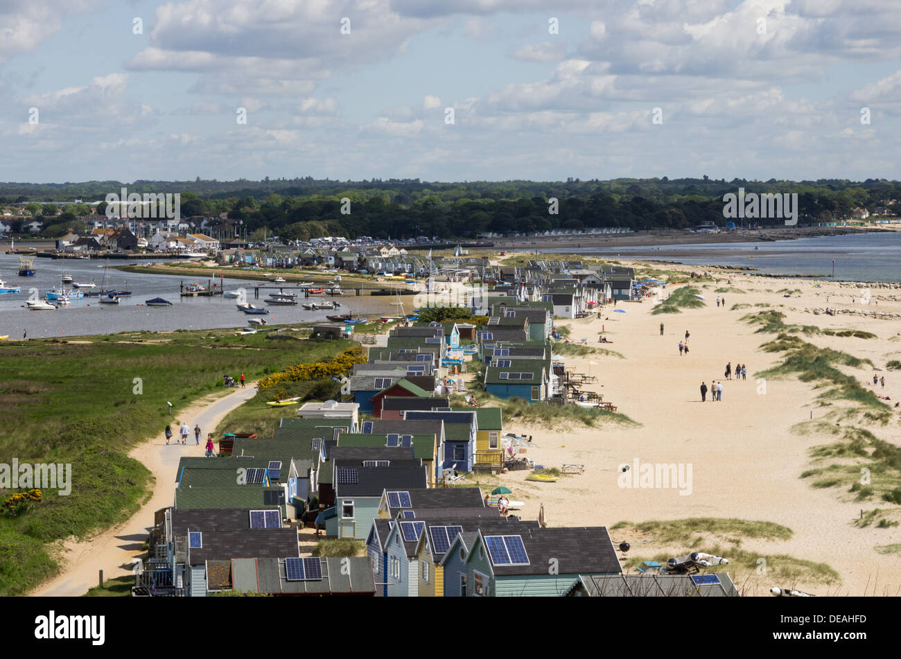 Una vista di testa Hangistbury verso Mudeford con i vacanzieri a piedi nelle dune lungo la spiaggia di molti-capanne. Foto Stock