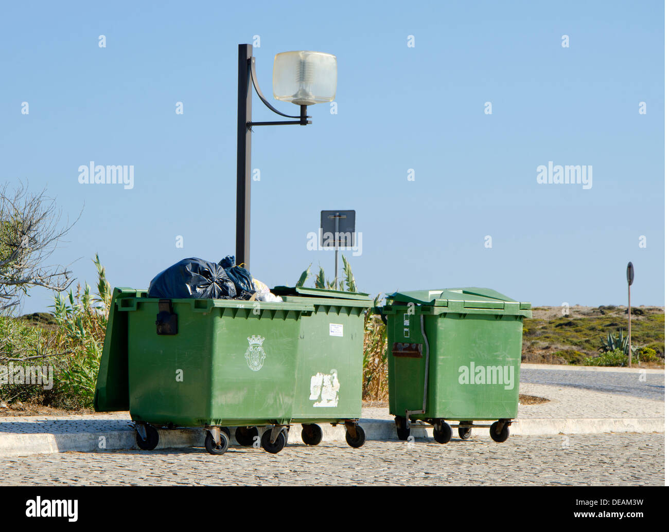 Tre discariche pubbliche contenitori su un posto di parcheggio Foto Stock