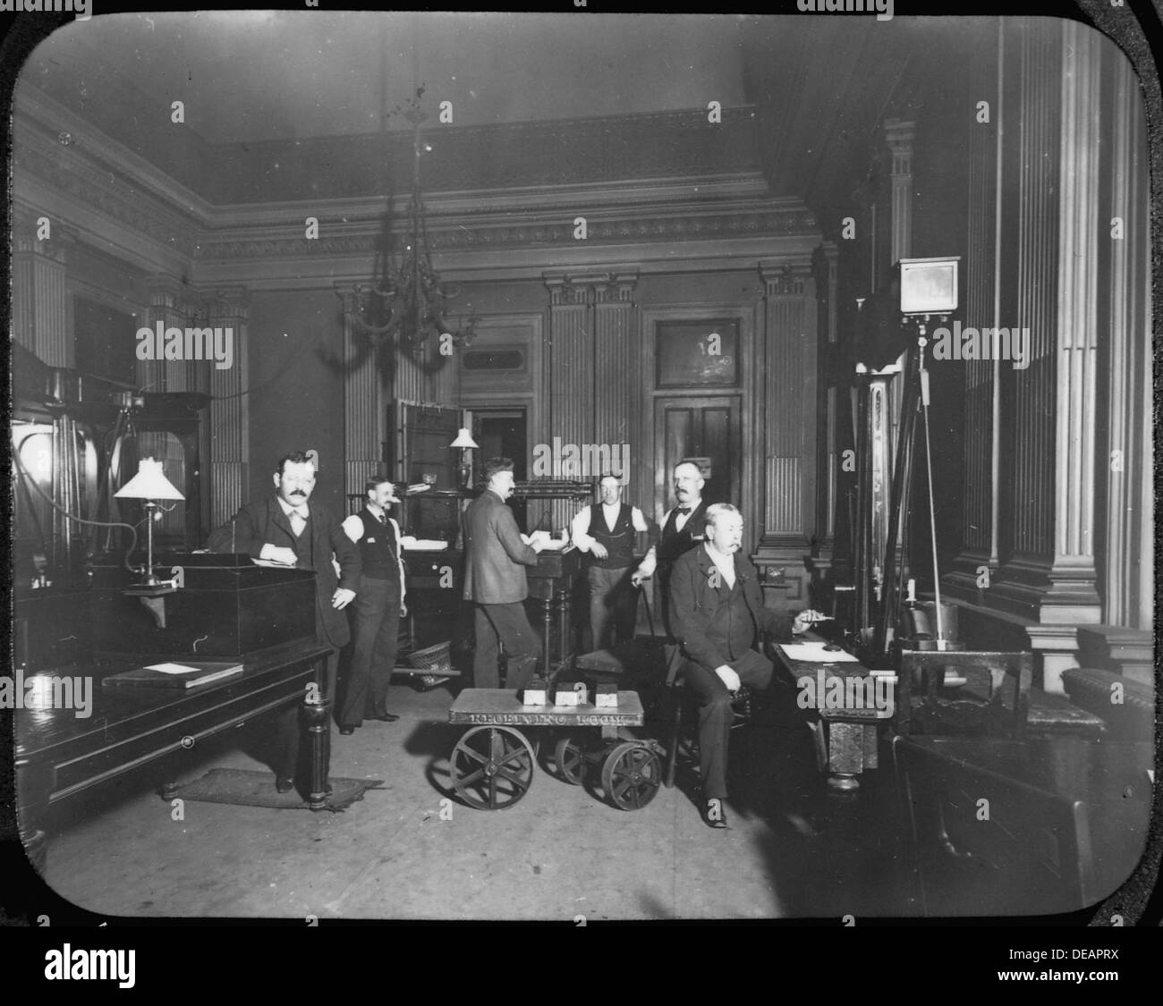 Una fotografia che mostra sei dipendenti che lavorano nella sala ricevimento della zecca di San Francisco, che gestiscono metalli e monete preziosi durante le loro operazioni di elaborazione. Foto Stock