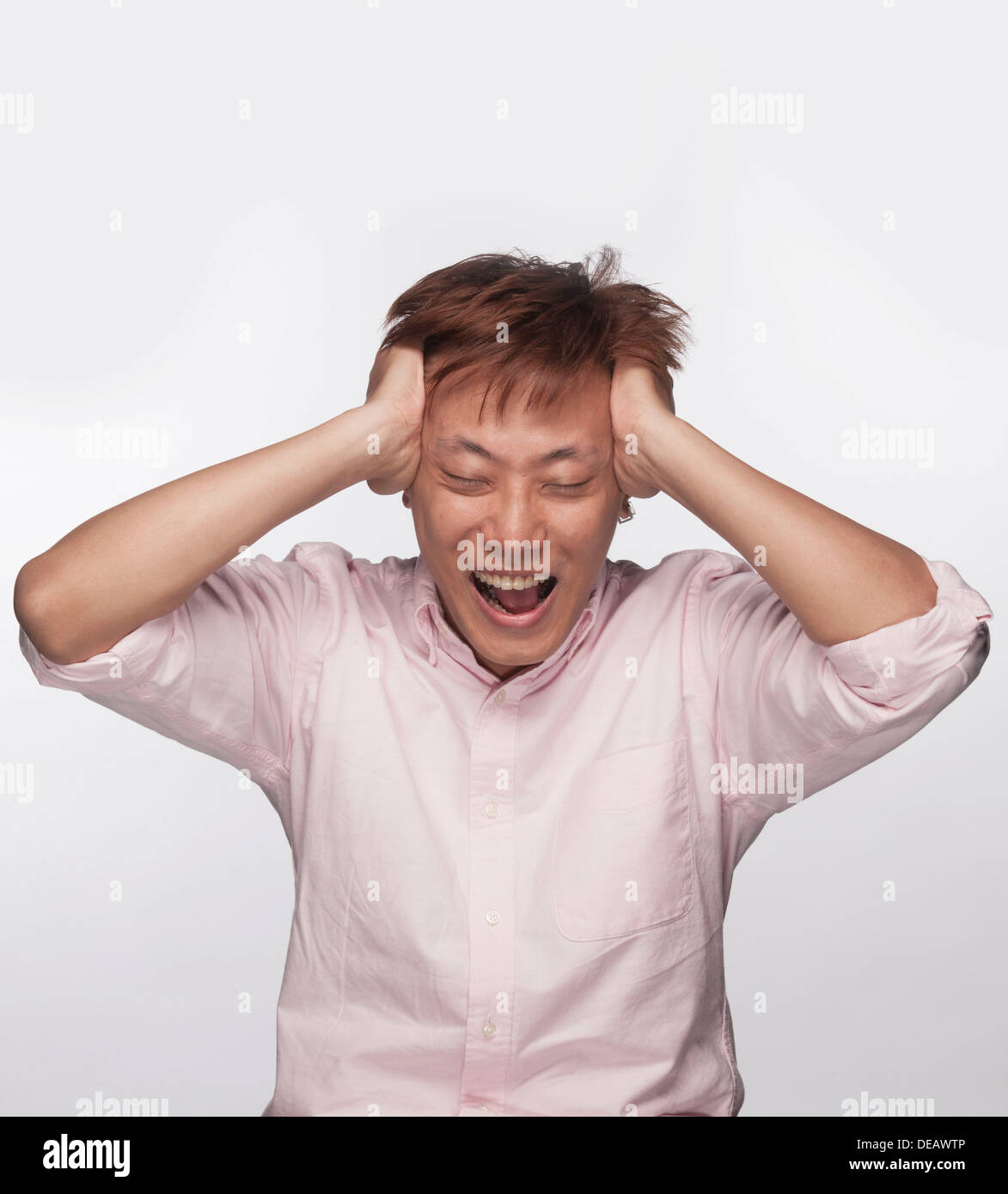 Frustrato uomo con le mani sulla testa e la bocca aperta, studio shot Foto Stock