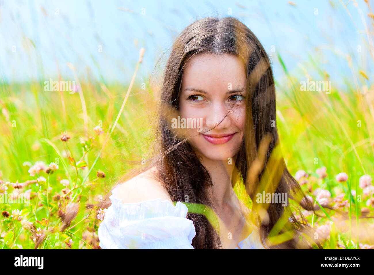 Giovane e bella ragazza in un campo di fiori Foto Stock
