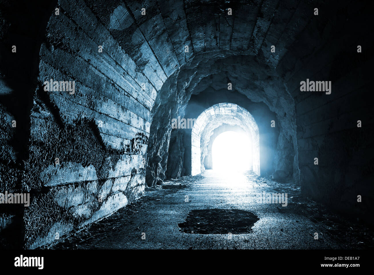 Incandescente uscire dal buio tunnel abbandonati. Monocromatico blu foto Foto Stock