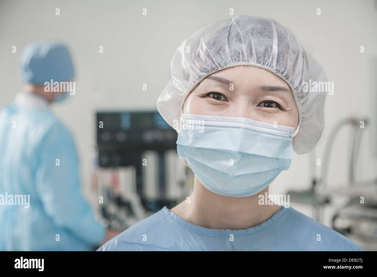 Ritratto di chirurgo con mascherina chirurgica e cappuccio chirurgica in sala  operatoria Foto stock - Alamy
