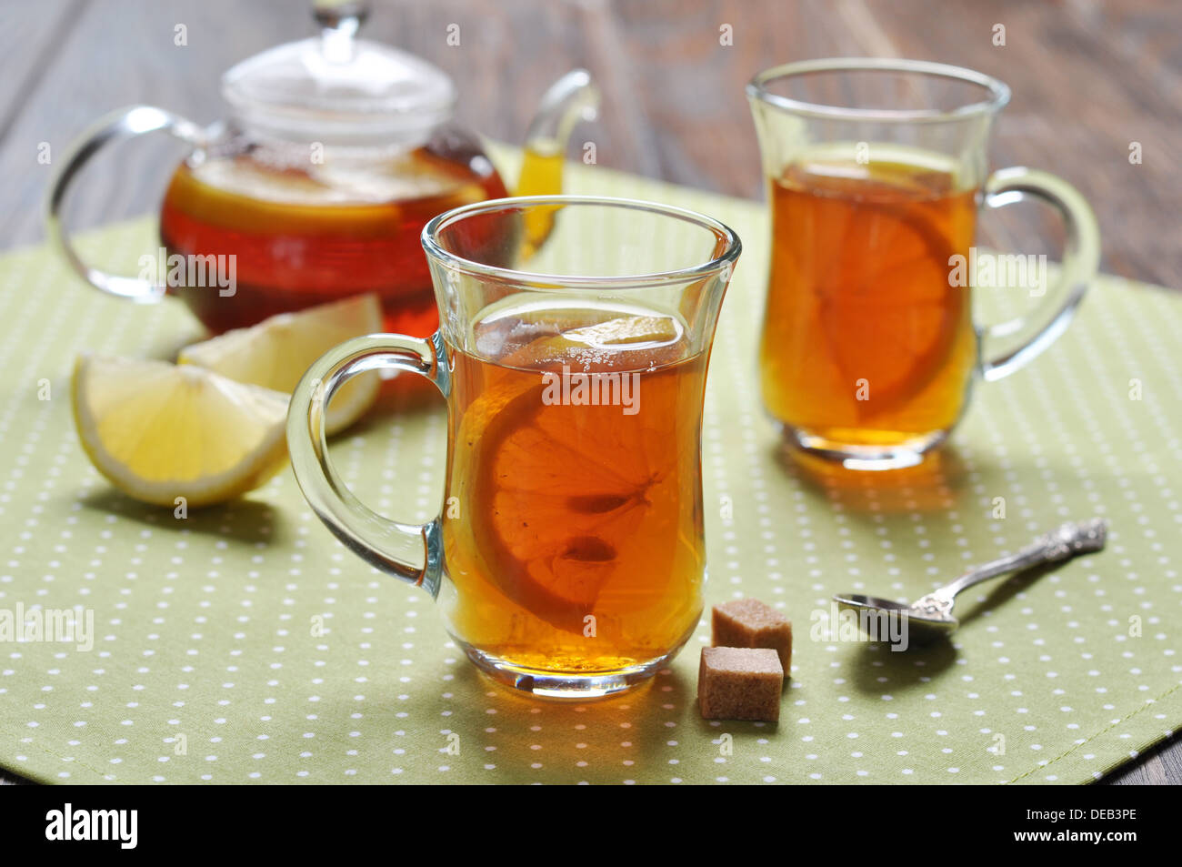 Tè con limone in bicchieri di vetro su sfondo di legno Foto Stock