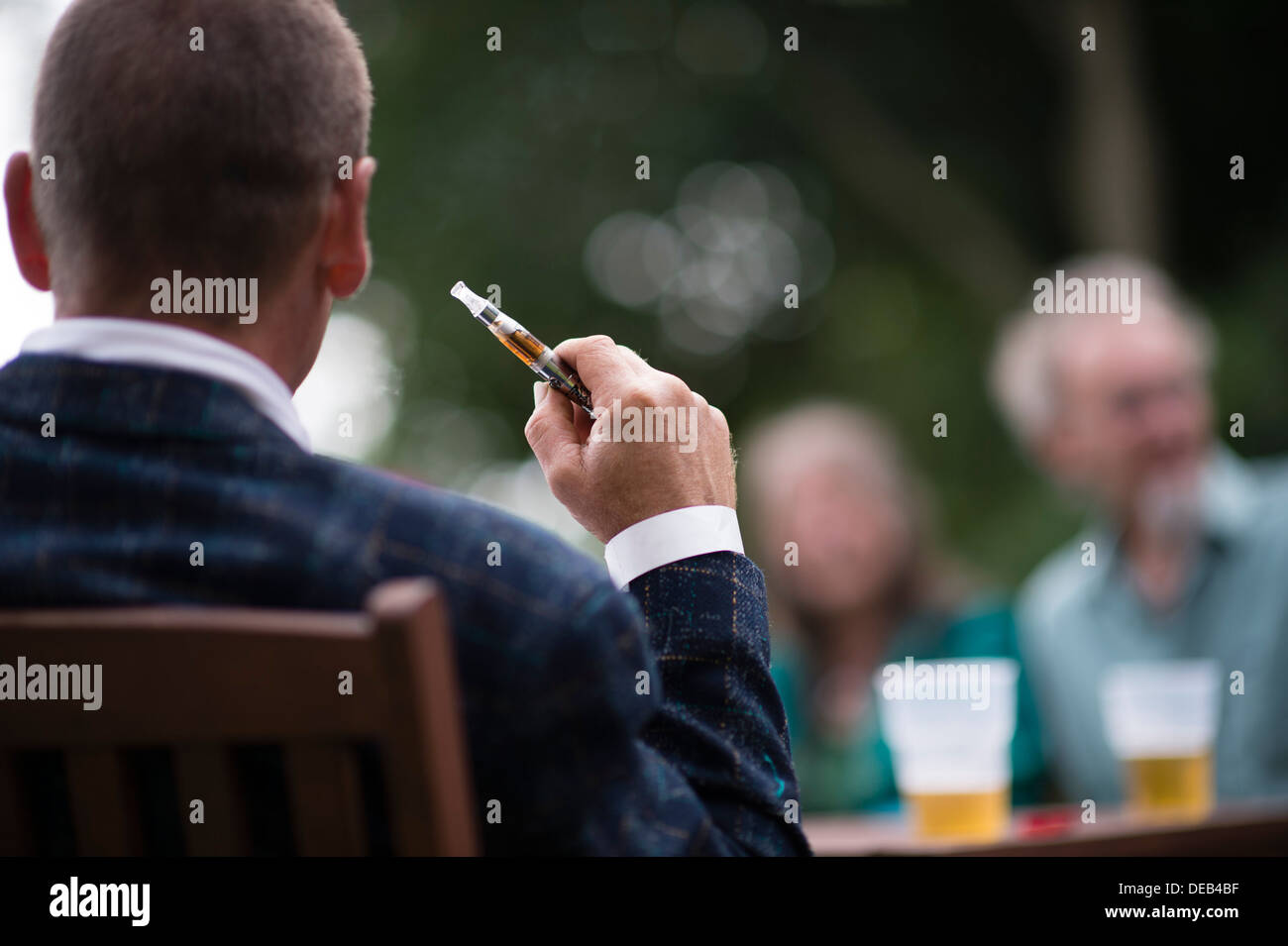 Un uomo con il fumo di una elettronica e-sigaretta a un partito esterno REGNO UNITO Foto Stock