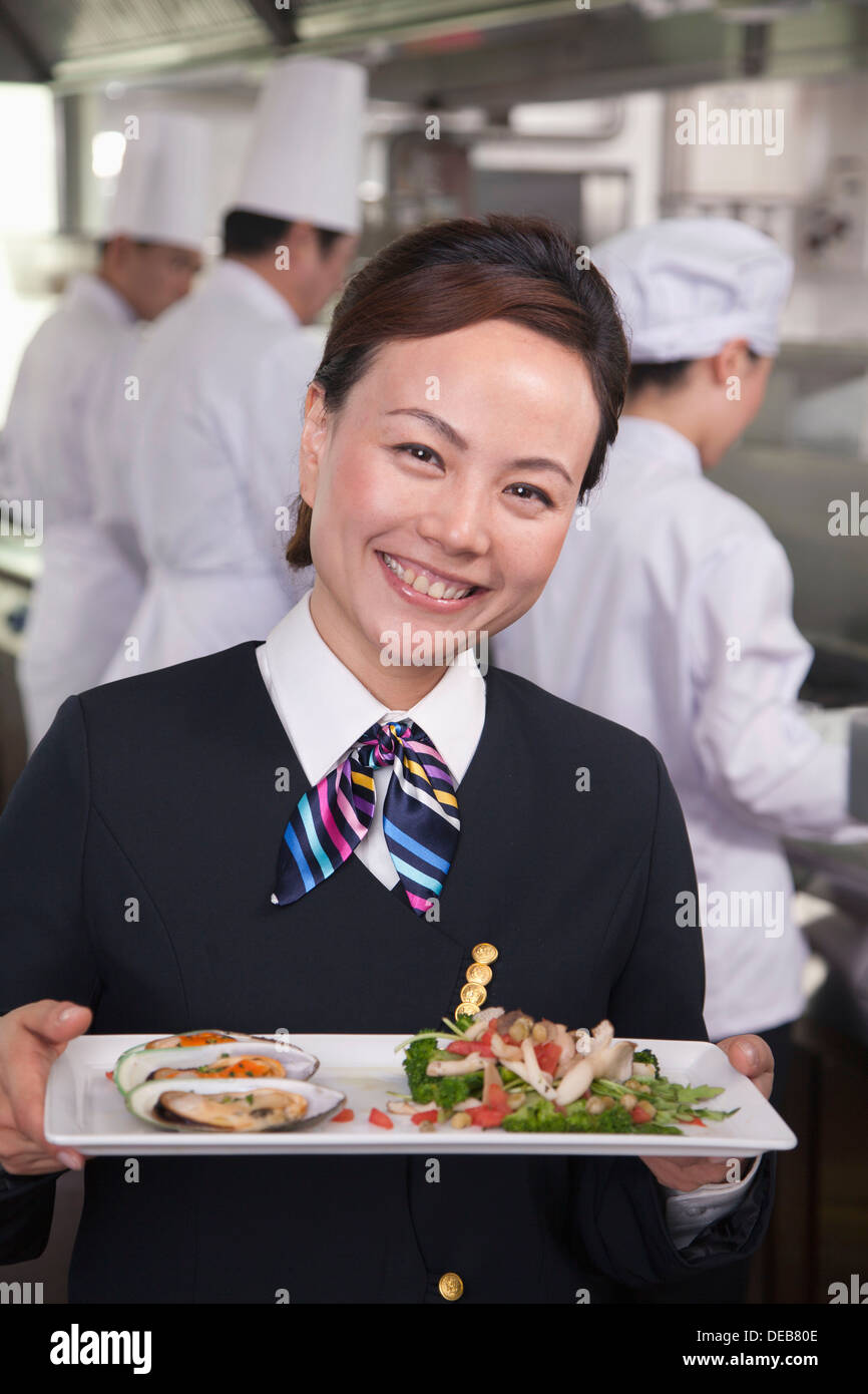Ristorante Hostess presentando piatto gourmet Foto Stock