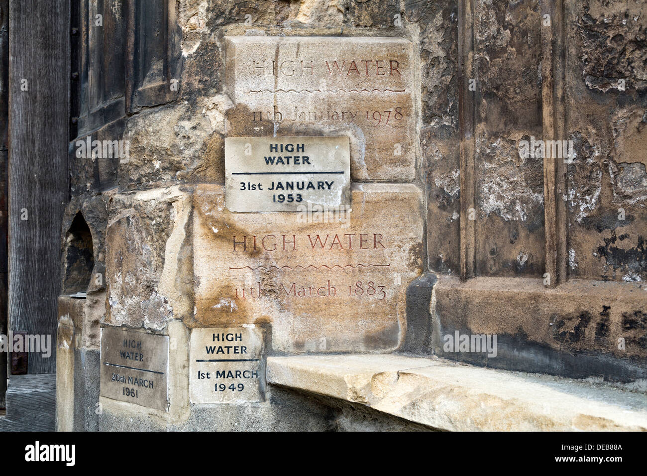 Acqua alta acqua di inondazione segna accanto alla porta a King's Lynn Minster, Norfolk, Inghilterra Foto Stock
