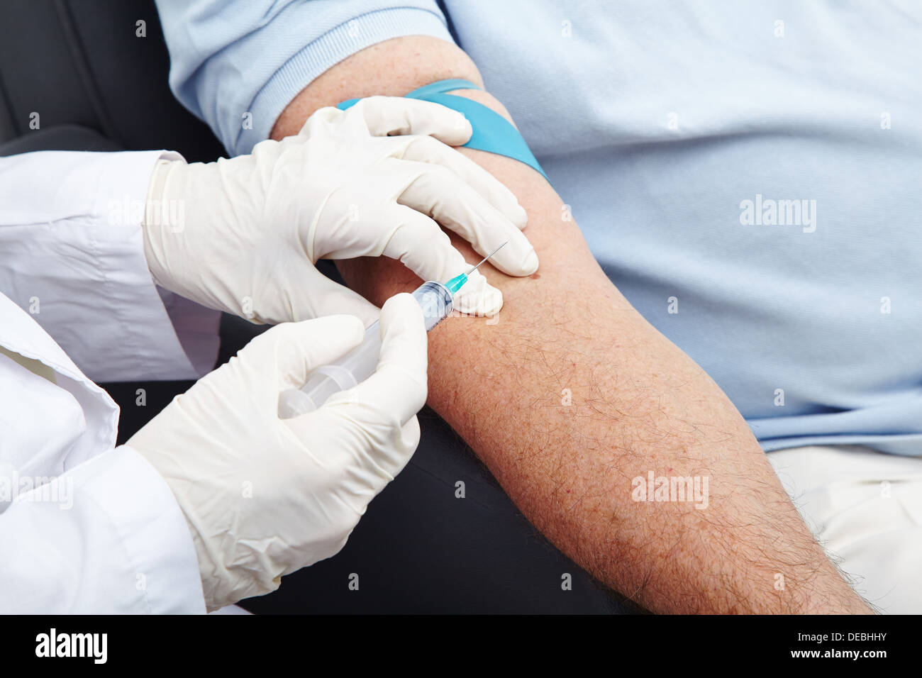 L uomo dando la donazione di sangue con la siringa nel suo braccio Foto Stock
