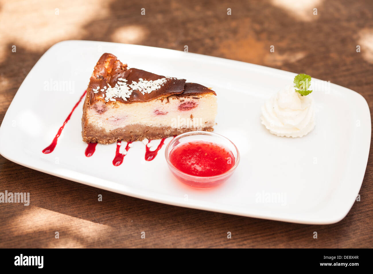 Cheesecake con crema chantilly e coulis Foto Stock